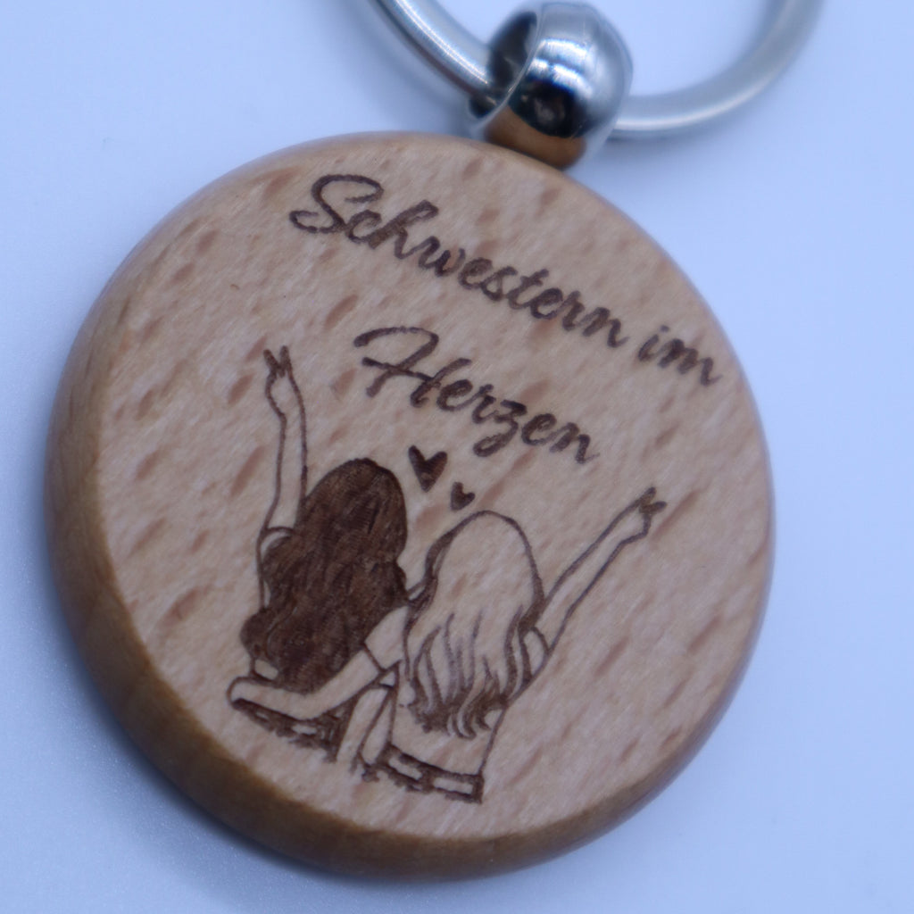 Detailaufnahme Gravur Schwestern im Herzen auf Holz Schlüsselanhänger personalisiertes Geschenk